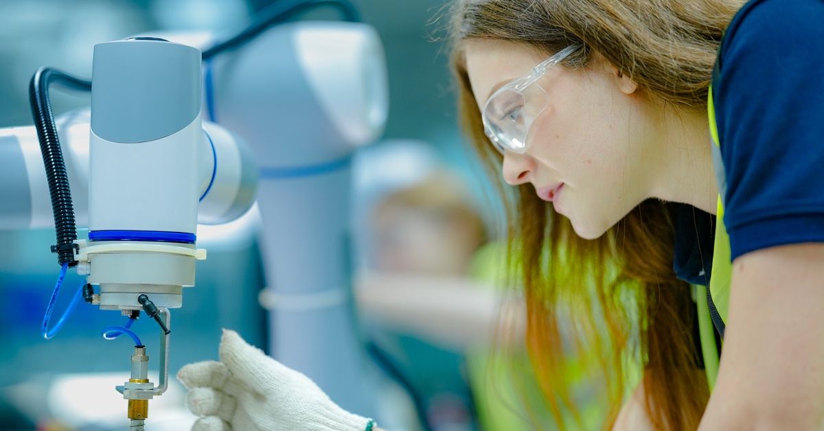 A technician attaching a device to a robotic fastening system. The device is designed for precise, automated assembly.