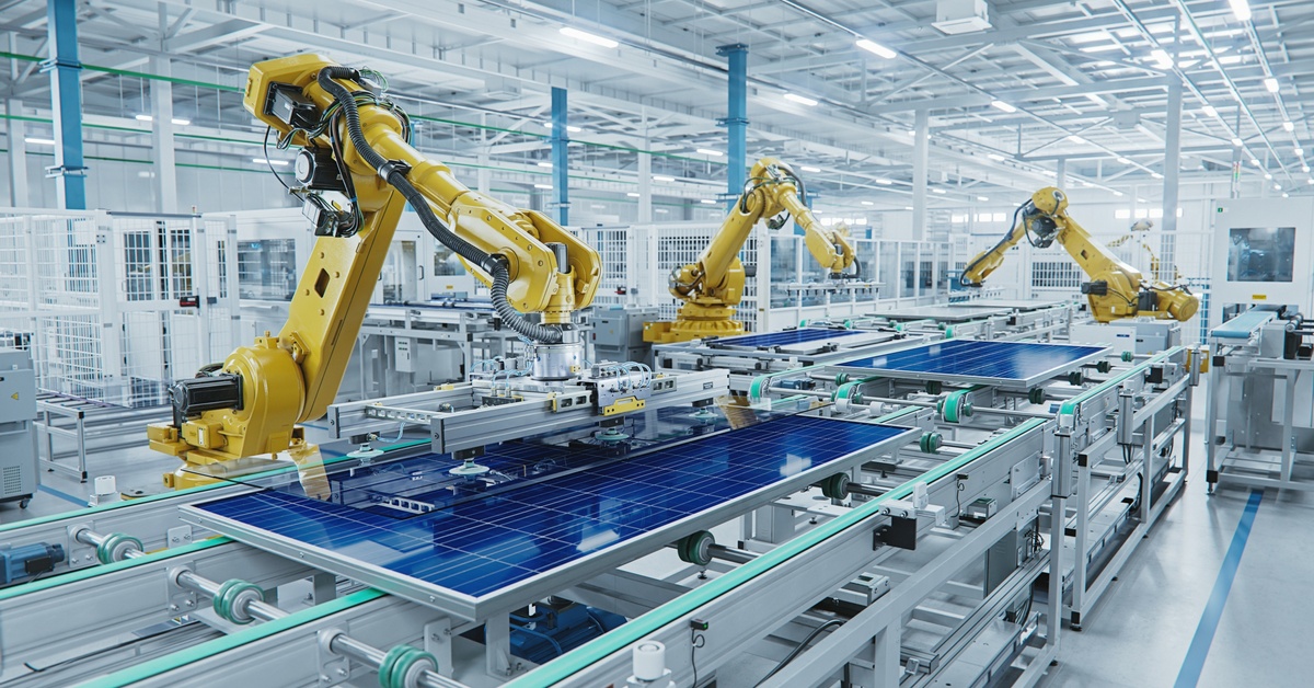  Inside a manufacturing warehouse. There is a large production line with industrial robot arms working.