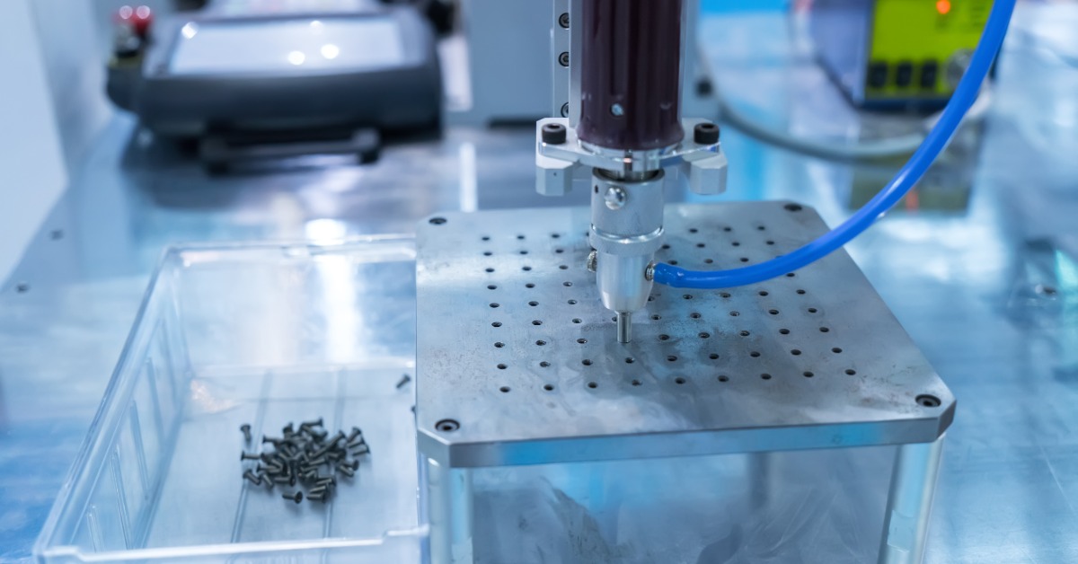 An automatic screw feeder in a cell phone assembly plant is inserting multiple screws into a line of metal.